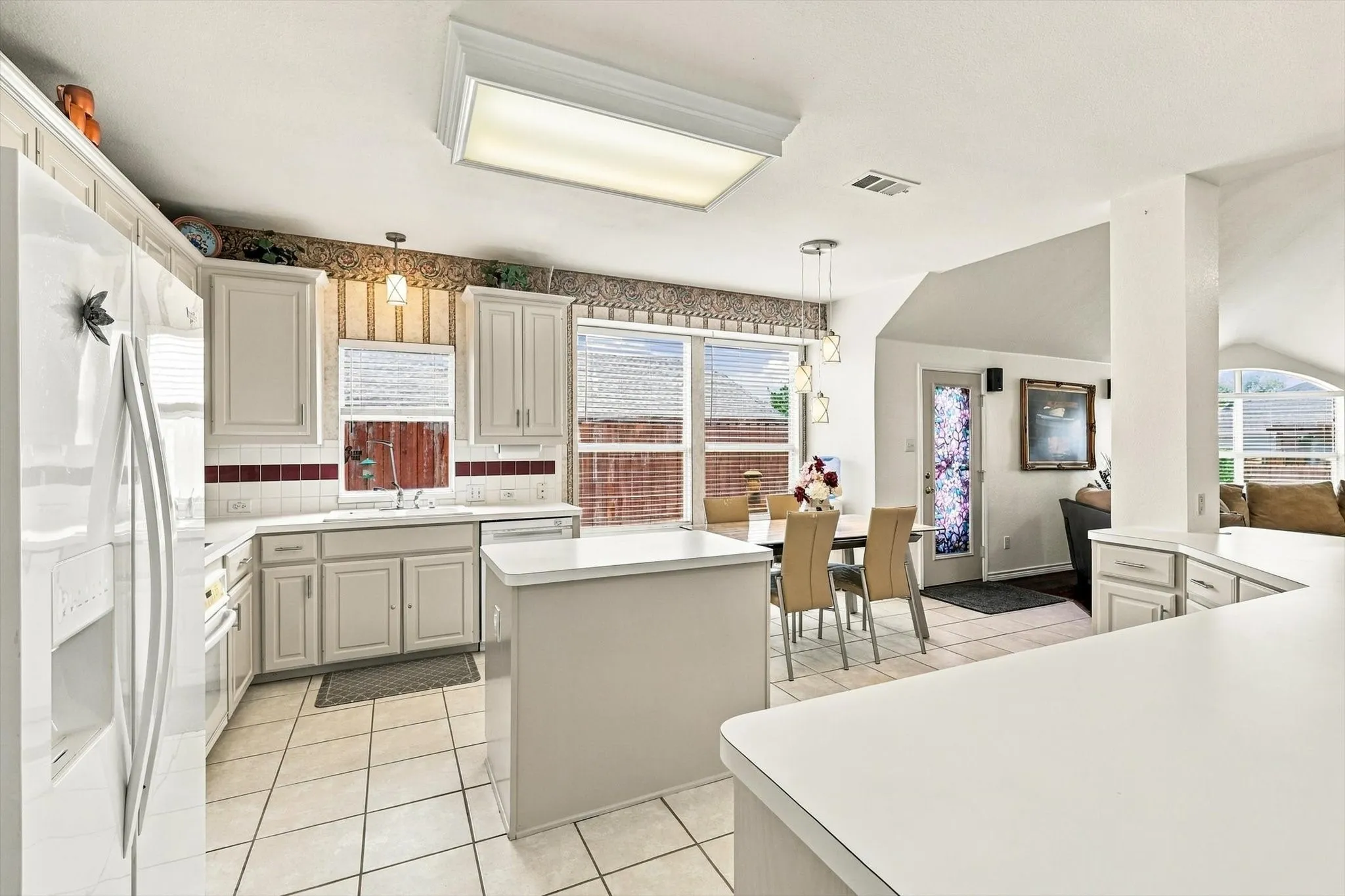 Kitchen with white cabinetry, tile flooring, and a center island
