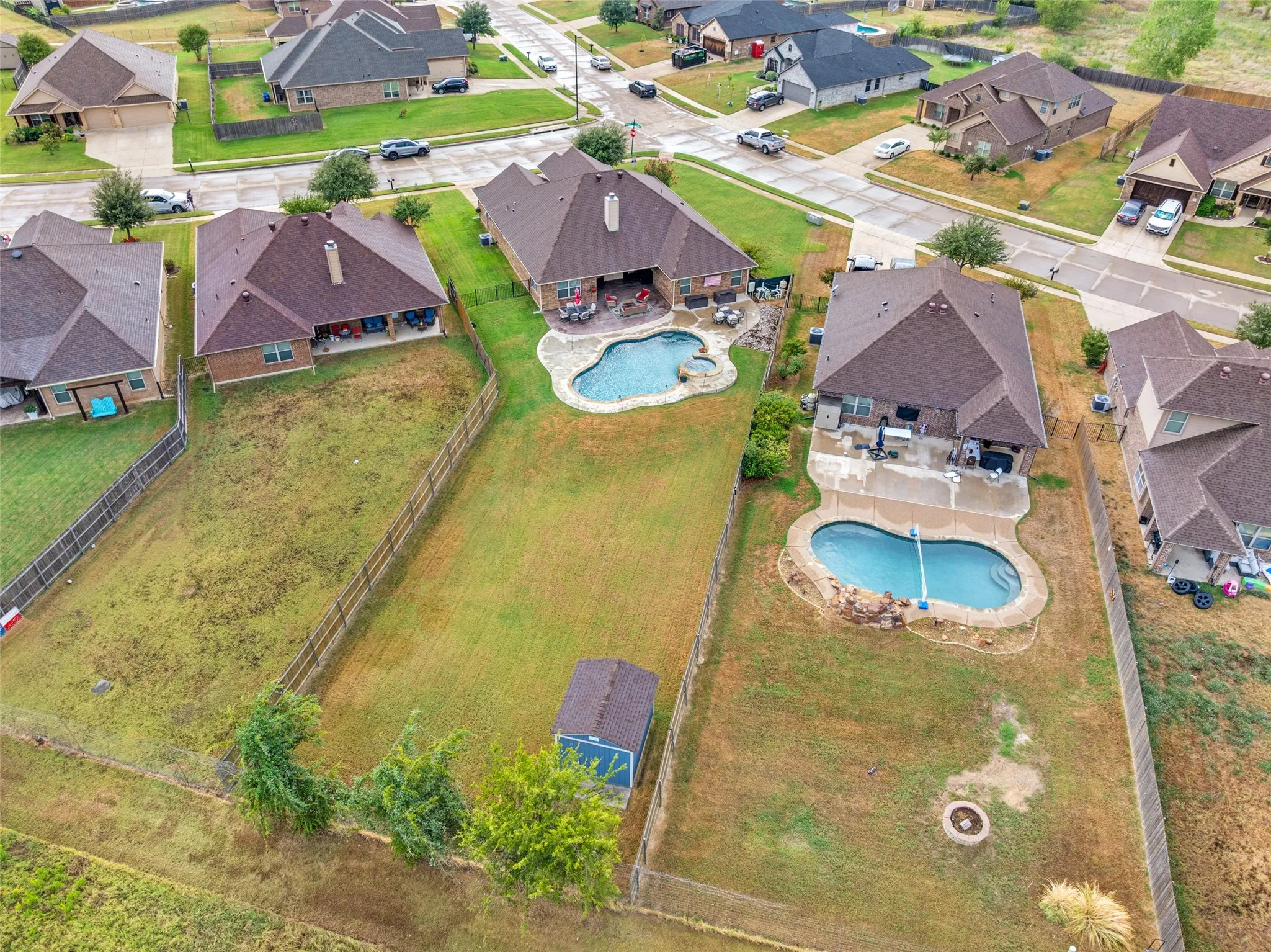 Outdoor entertaining space featuring a kidney-shaped pool with integrated spa and a concrete patio