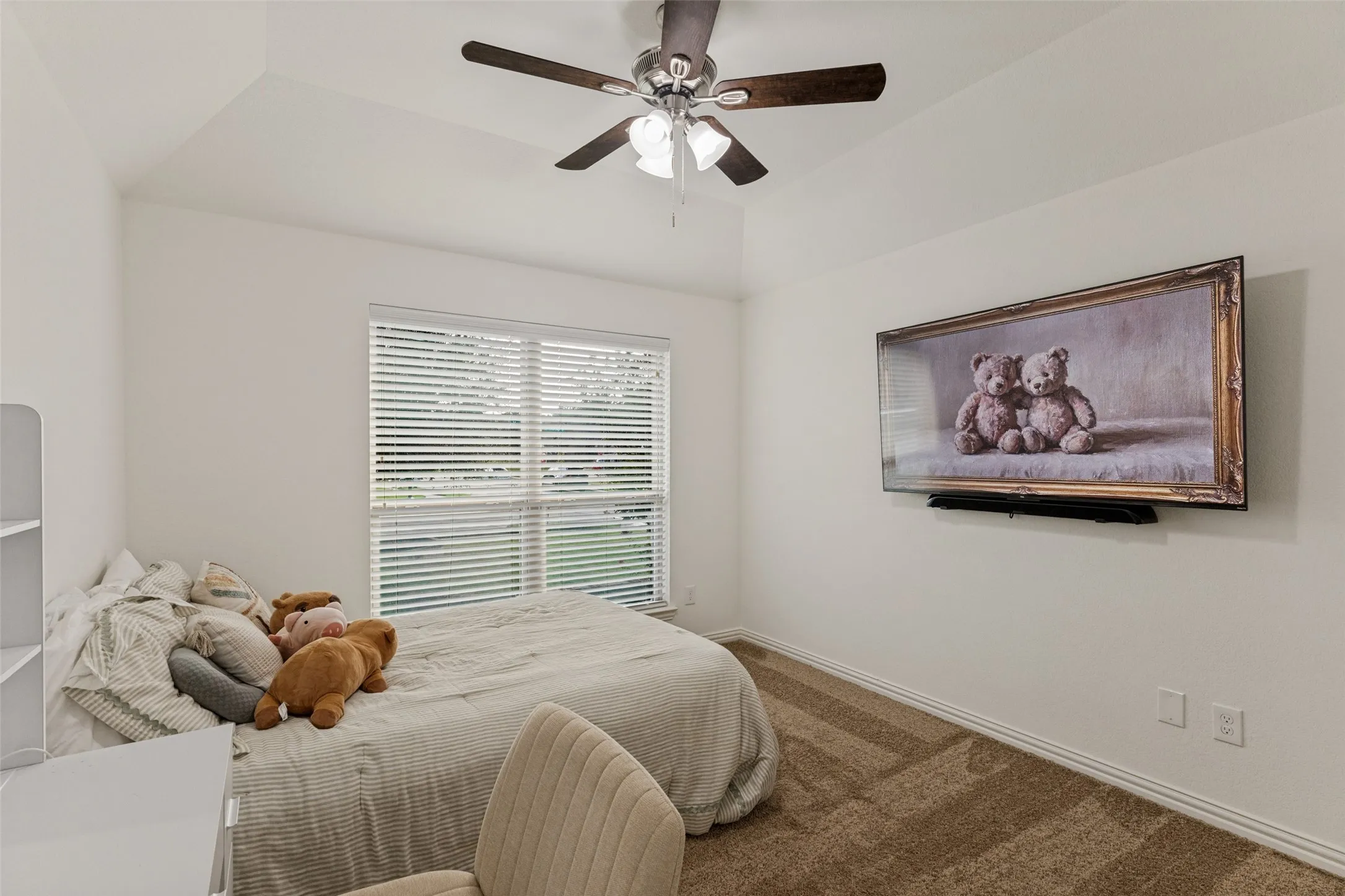 Vaulted ceiling with a ceiling fan, window with blinds, and neutral carpet flooring