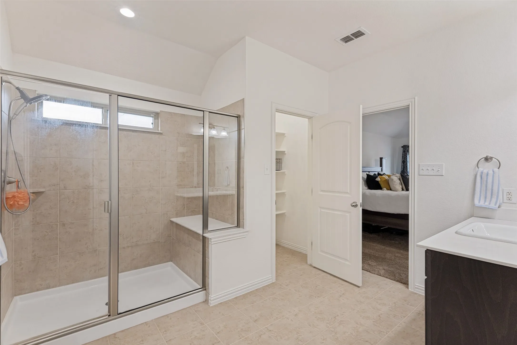 Walk-in shower with tiled walls, built-in bench, and sliding glass enclosure