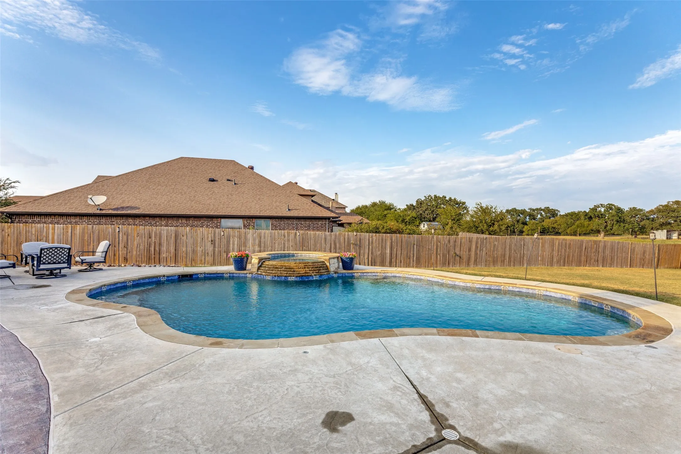 Resort-style pool with integrated spa and waterfall feature