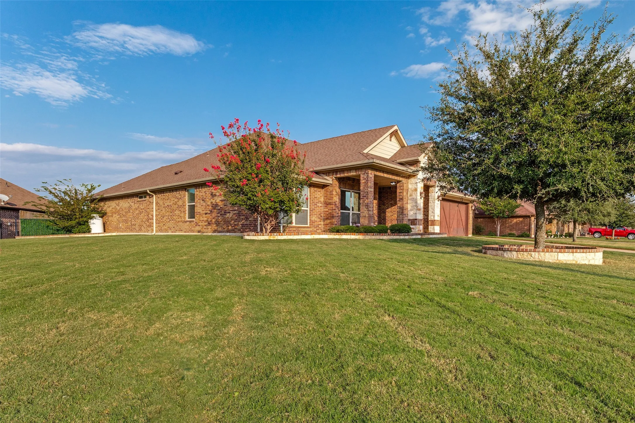 Brick exterior with stone accents, a prominent covered entry, and an attached garage