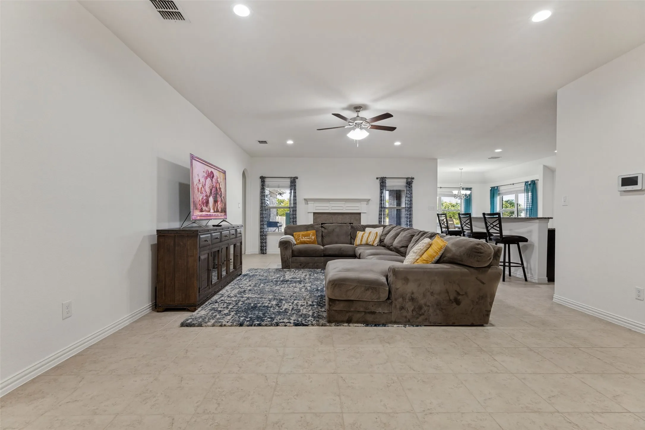 Recessed lighting, ceiling fan, fireplace with mantel, and tile flooring