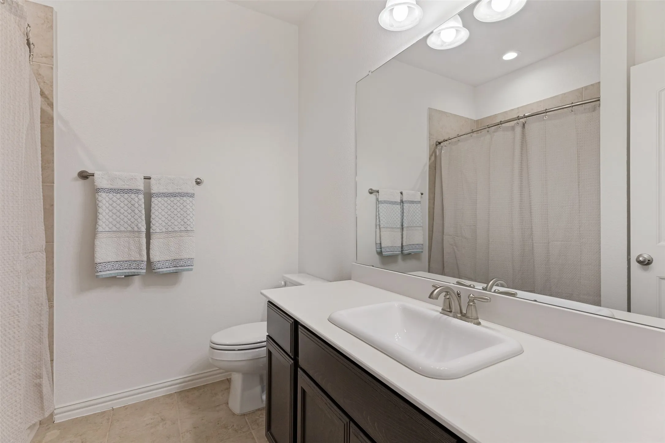 Vanity featuring a white countertop, undermount sink, and brushed nickel faucet