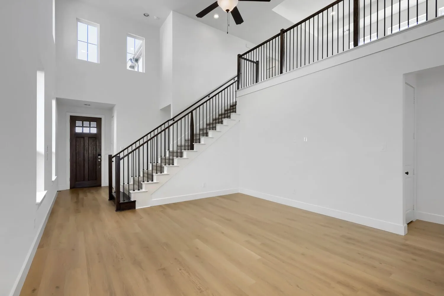Dramatic two-story foyer with soaring ceilings and abundant natural light from upper windows