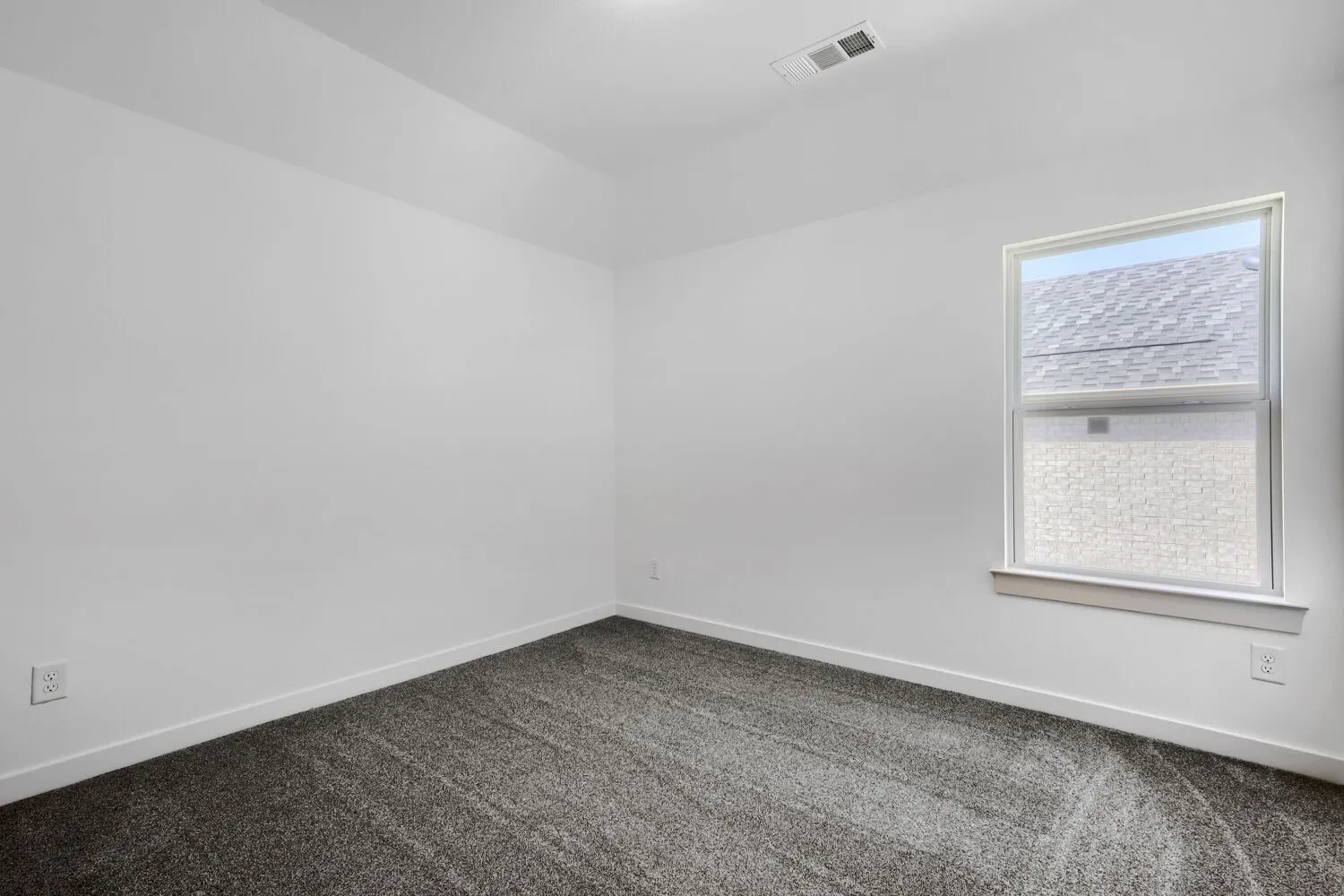 Window with white trim, gray textured carpeting, and white walls