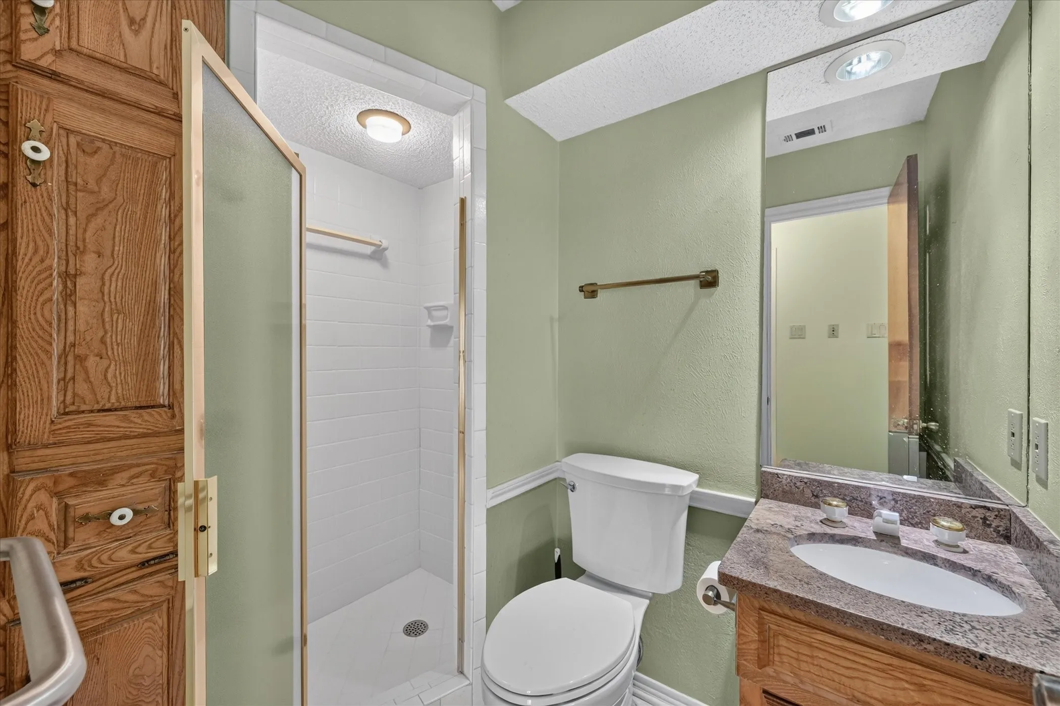White tile shower with frosted glass enclosure