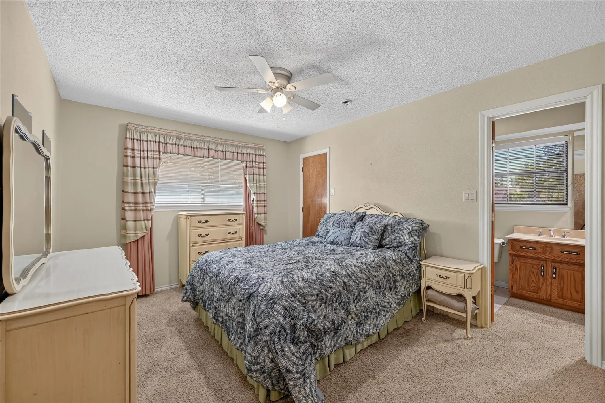 Recessed window with blinds, ceiling fan with integrated lighting, wood-finish door, and carpeted flooring