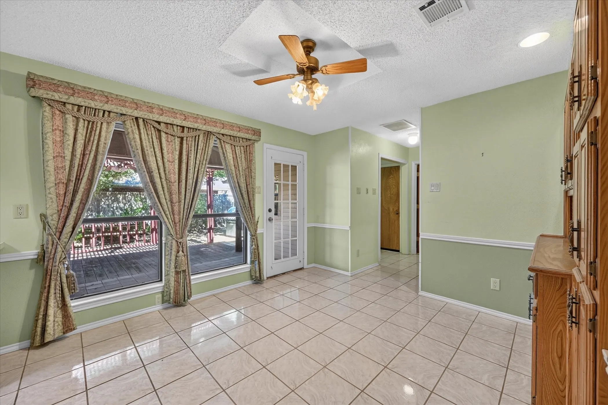 Tile flooring, built-in cabinetry, ceiling fan with light fixture, recessed lighting, and a glass-paneled door
