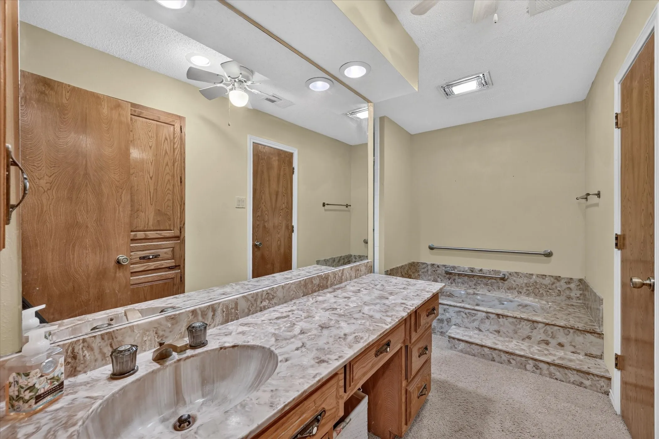Extended vanity with integrated sink, full-width mirror, and ample wood cabinetry