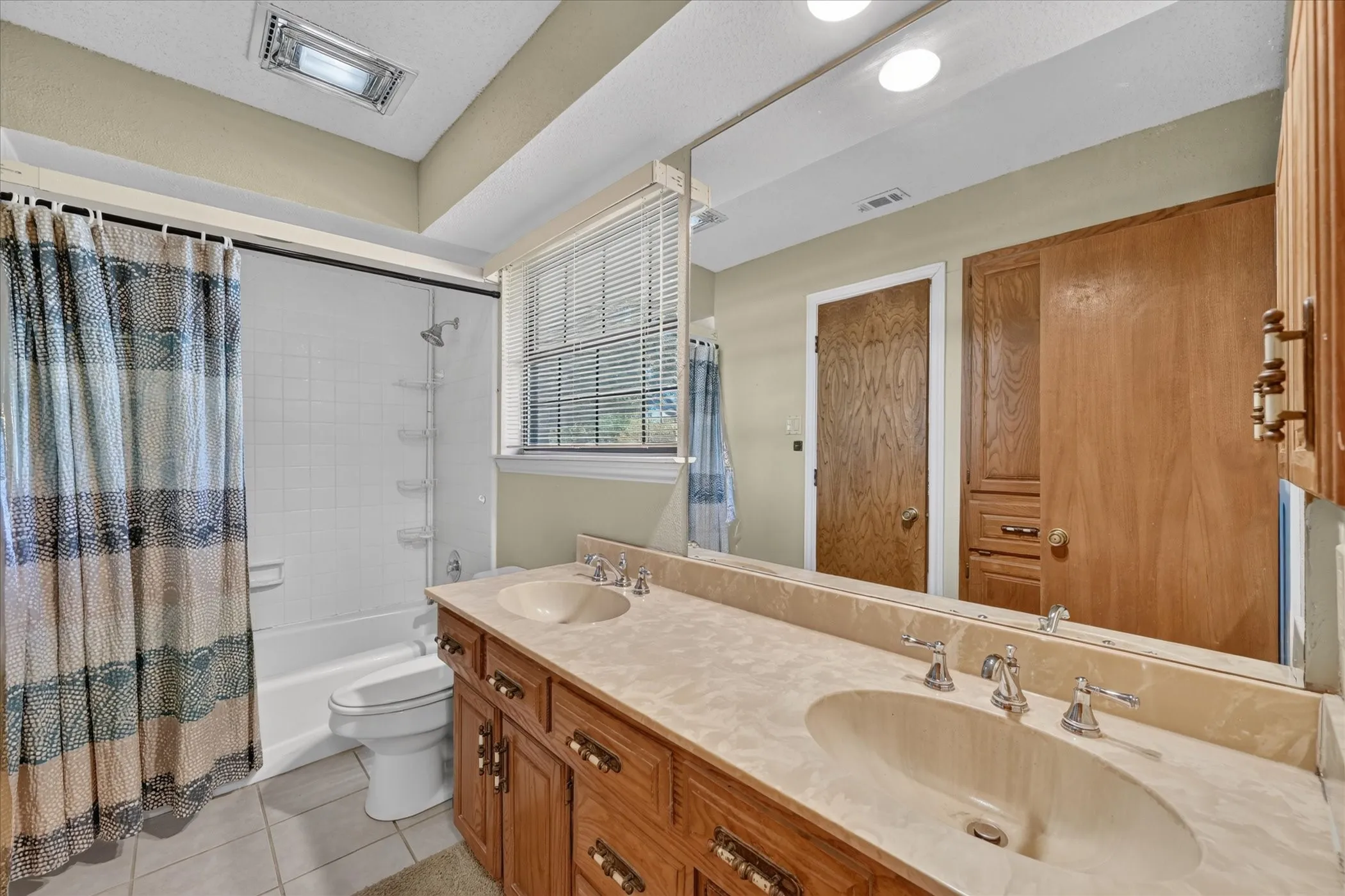 Double vanity with integrated sinks, wood cabinetry, and chrome fixtures