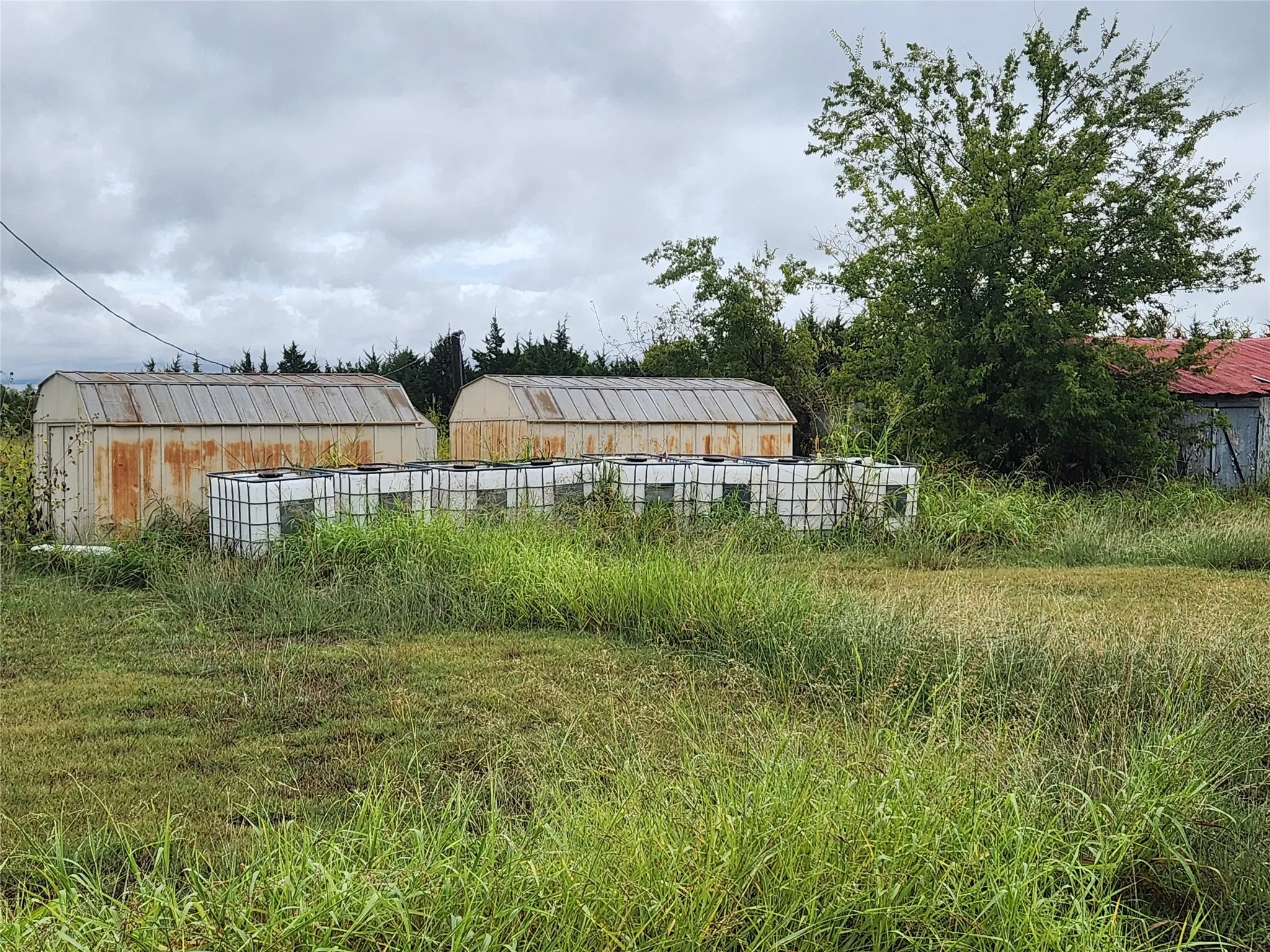 Storage sheds and water tanks on property.