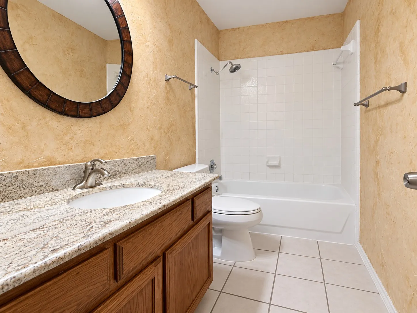 Vanity with a granite-style countertop, a built-in sink, and a brushed nickel faucet