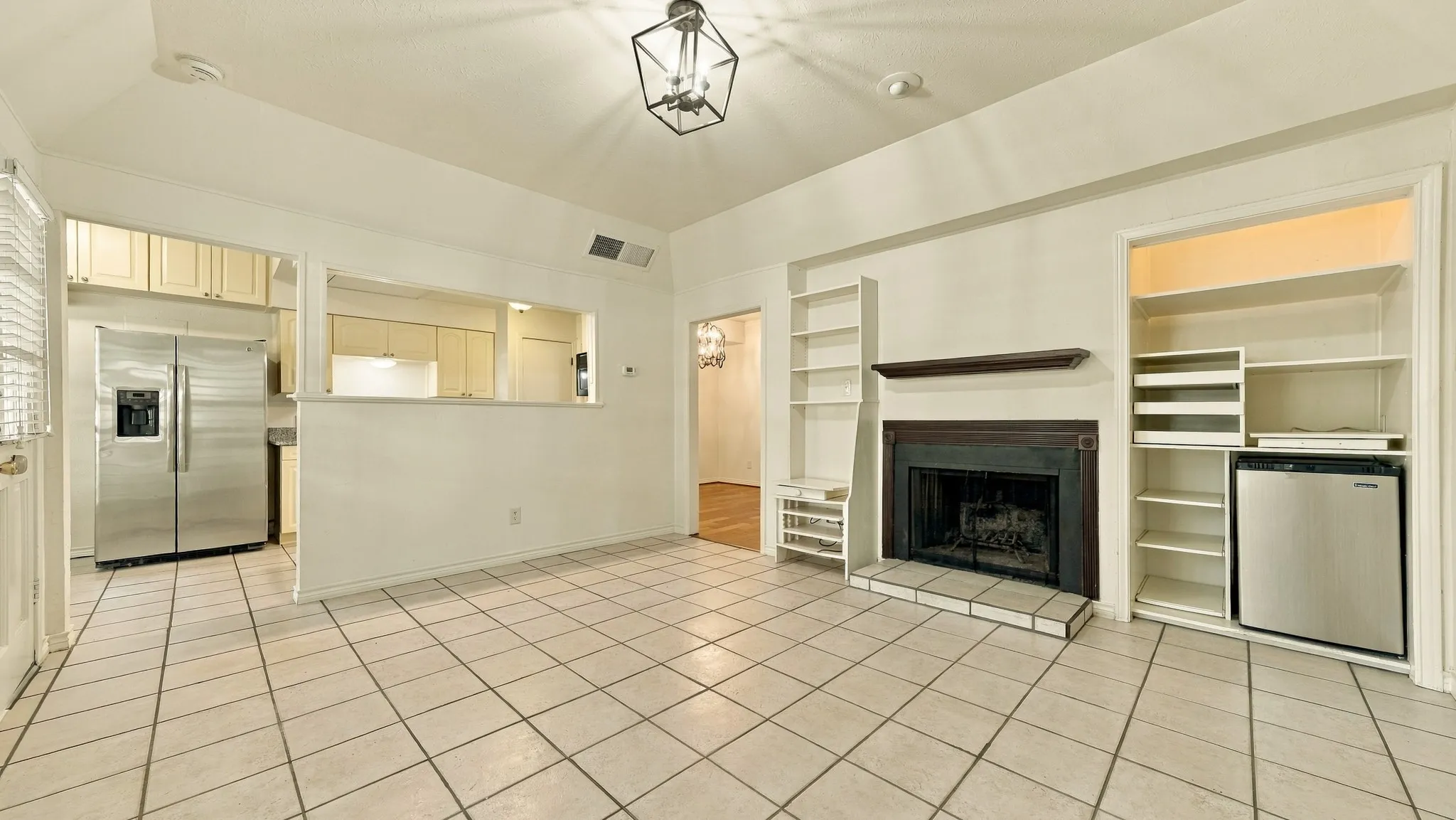 den wood burning fireplace, built in shelves, mini frig, view to kitchen