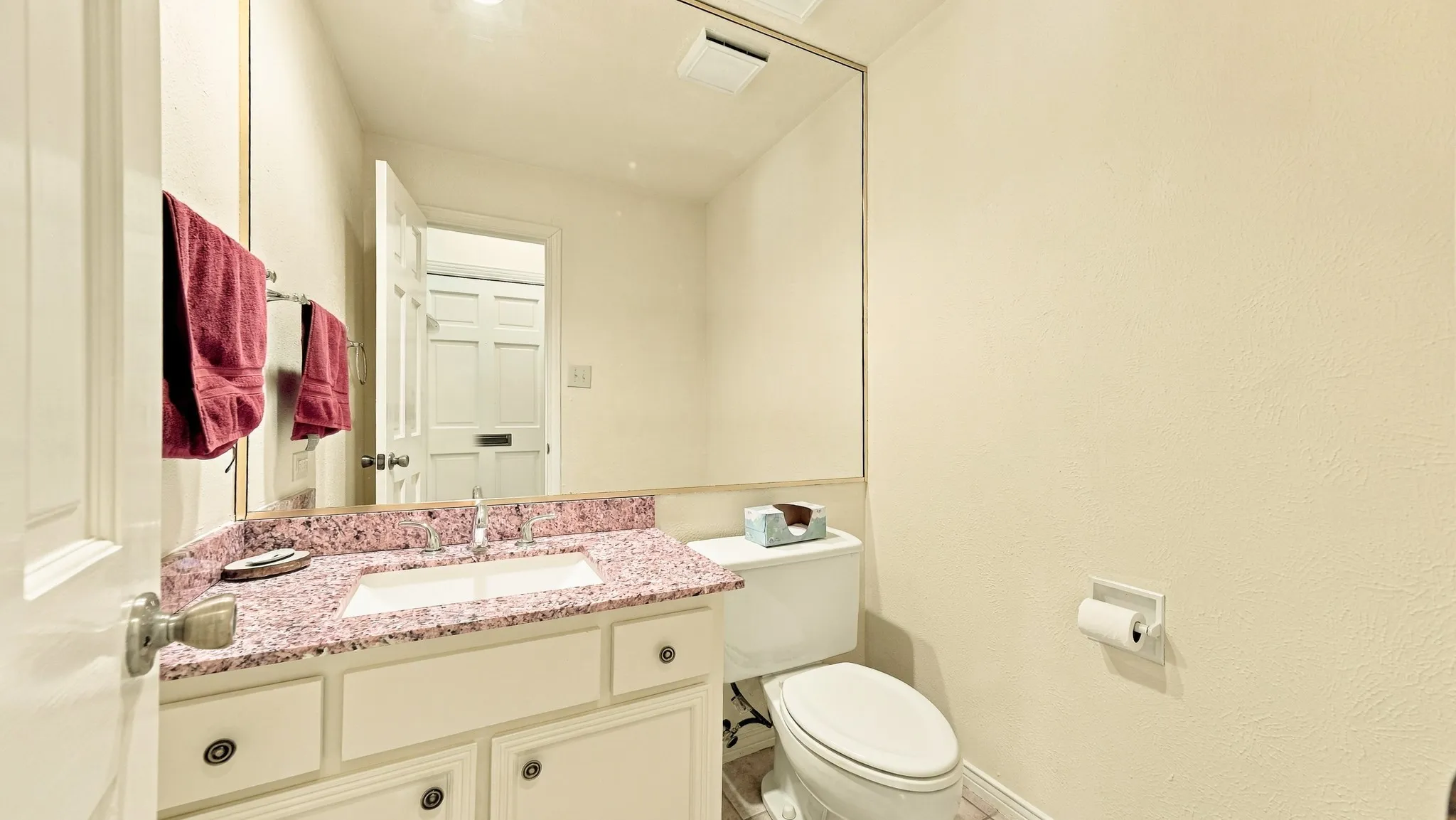 half bath by front door, granite, drawers, cabinets