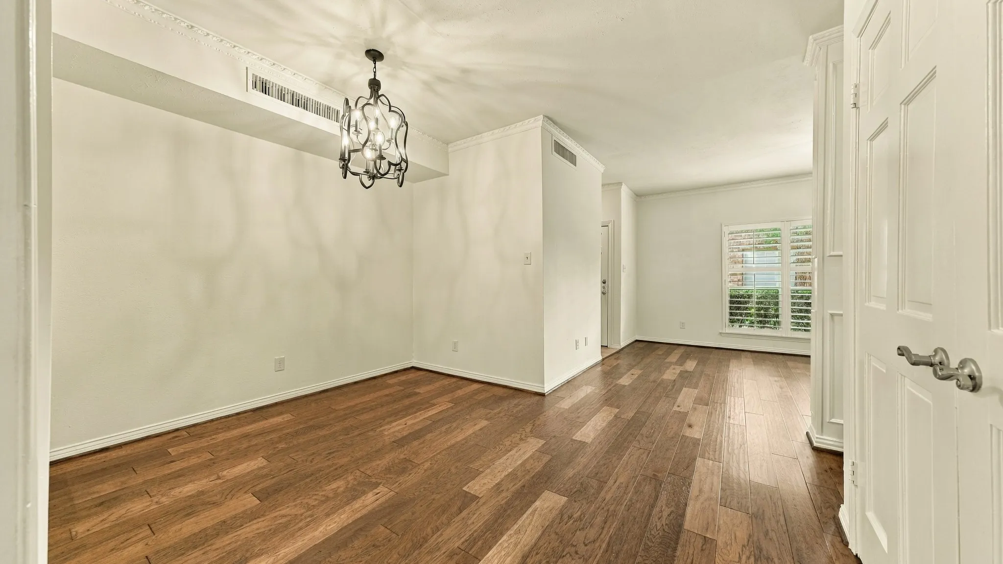 standing at den door view of dining & living rooms, newer wood plank floors, crown moldig,high ceiling's