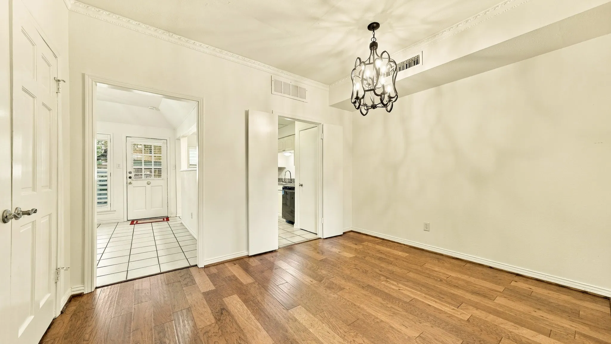 center of home, new modern light fixture, door into kitchen, door into den