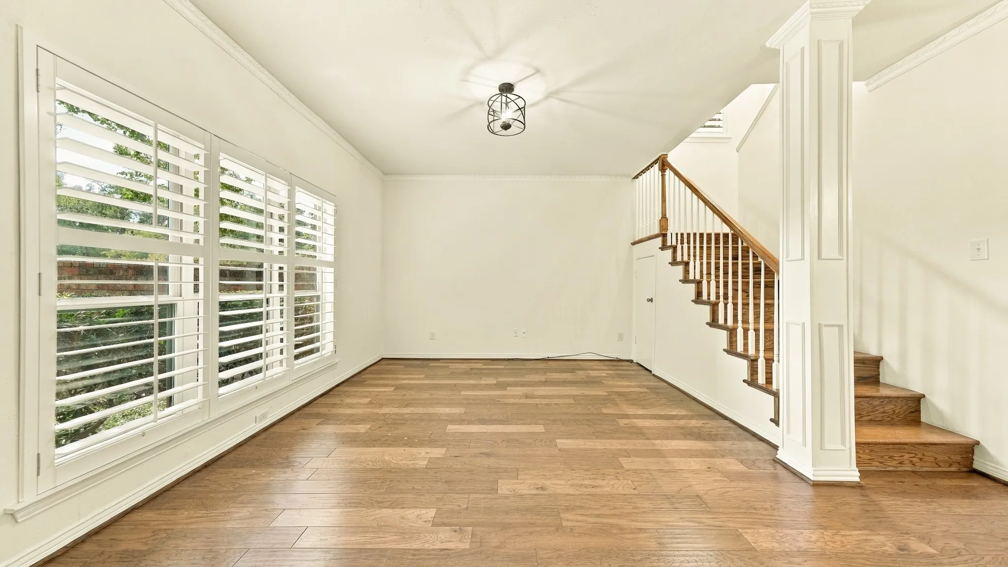 living room newer windows and plantation shutters,newwer wood staircas