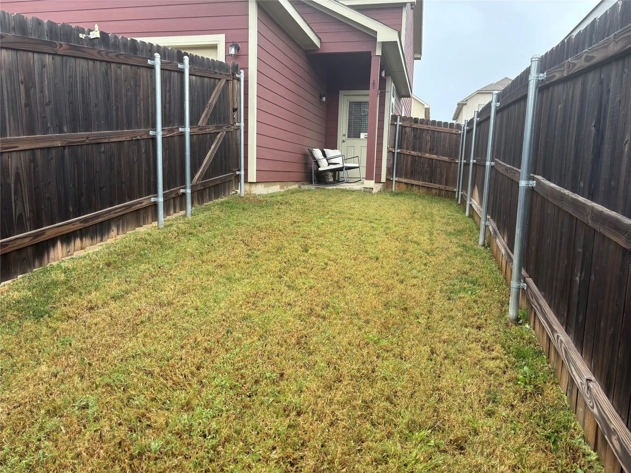 Private backyard space with wood fencing and a exterior door