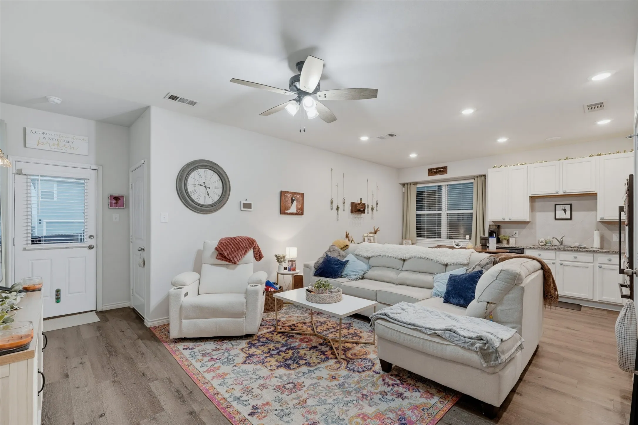 Open-concept living area featuring wood-finish flooring, recessed lighting, and a ceiling fan
