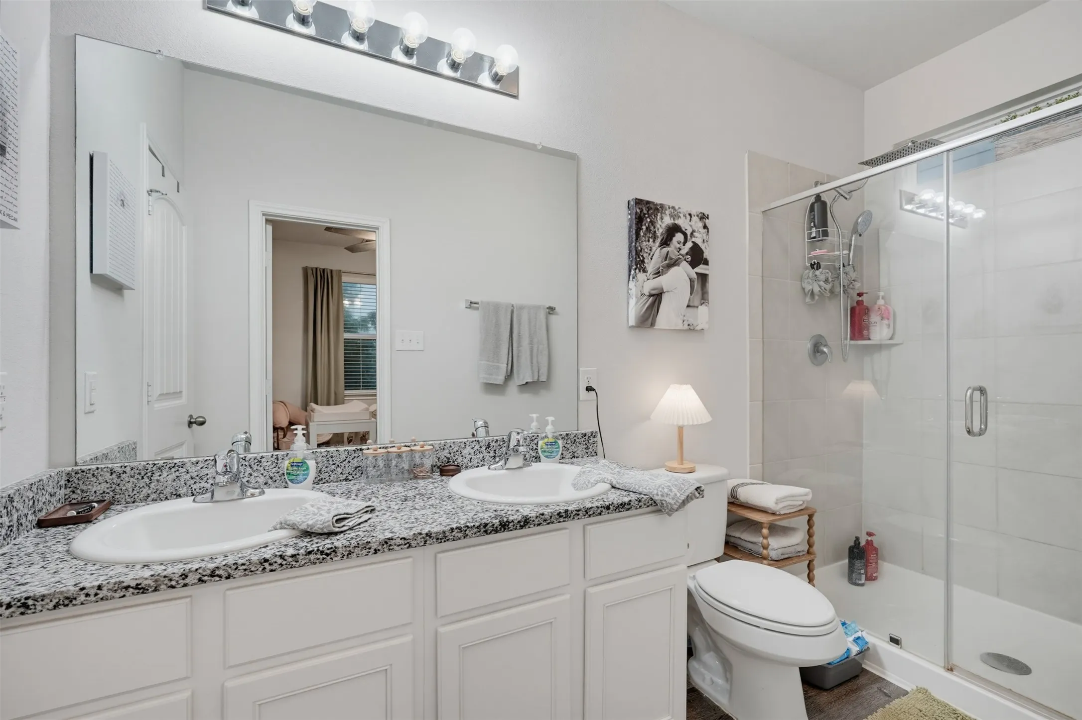 Dual vanity with undermount sinks, speckled countertop, and chrome fixtures