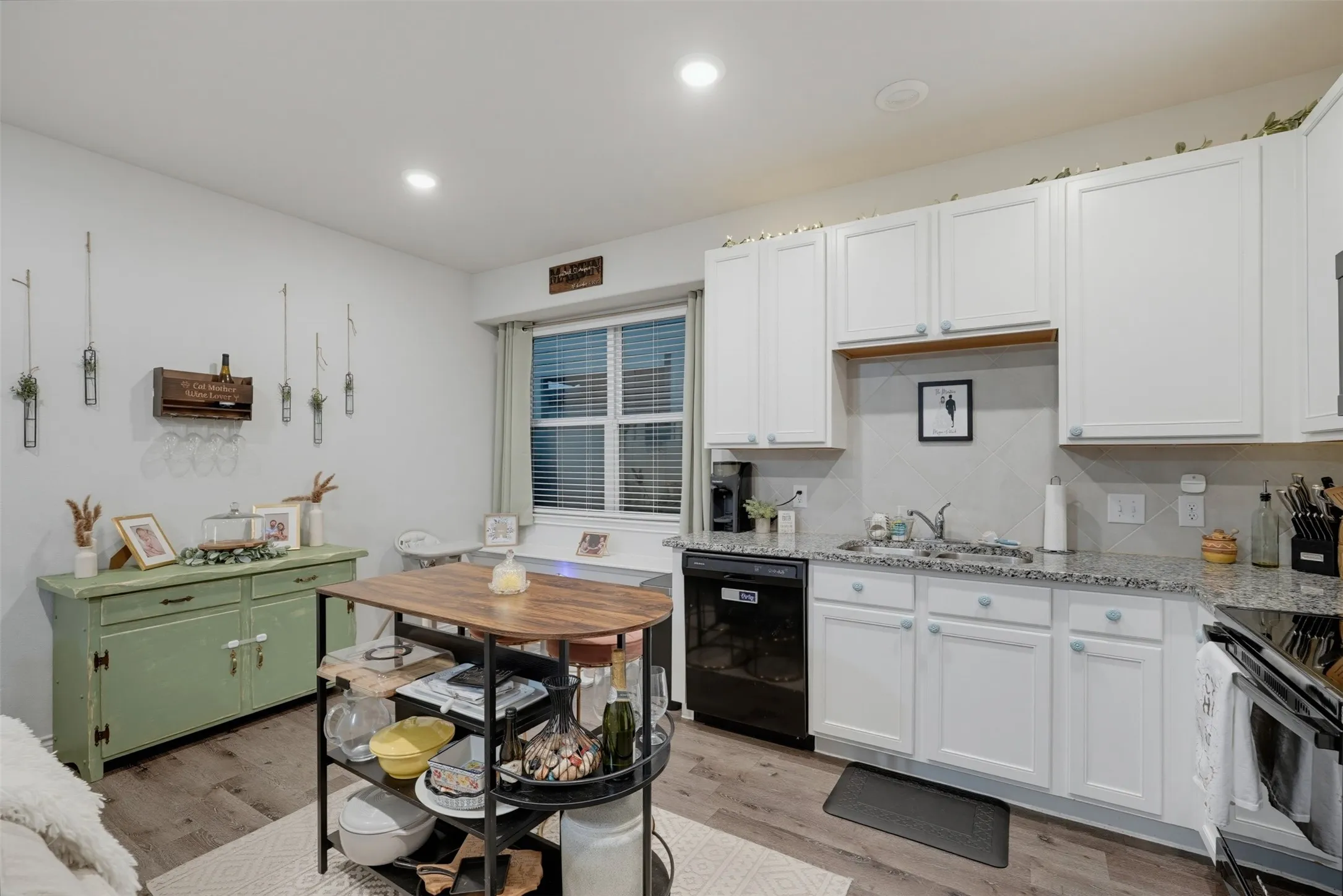 White shaker-style cabinetry, granite countertops, and stainless steel sink