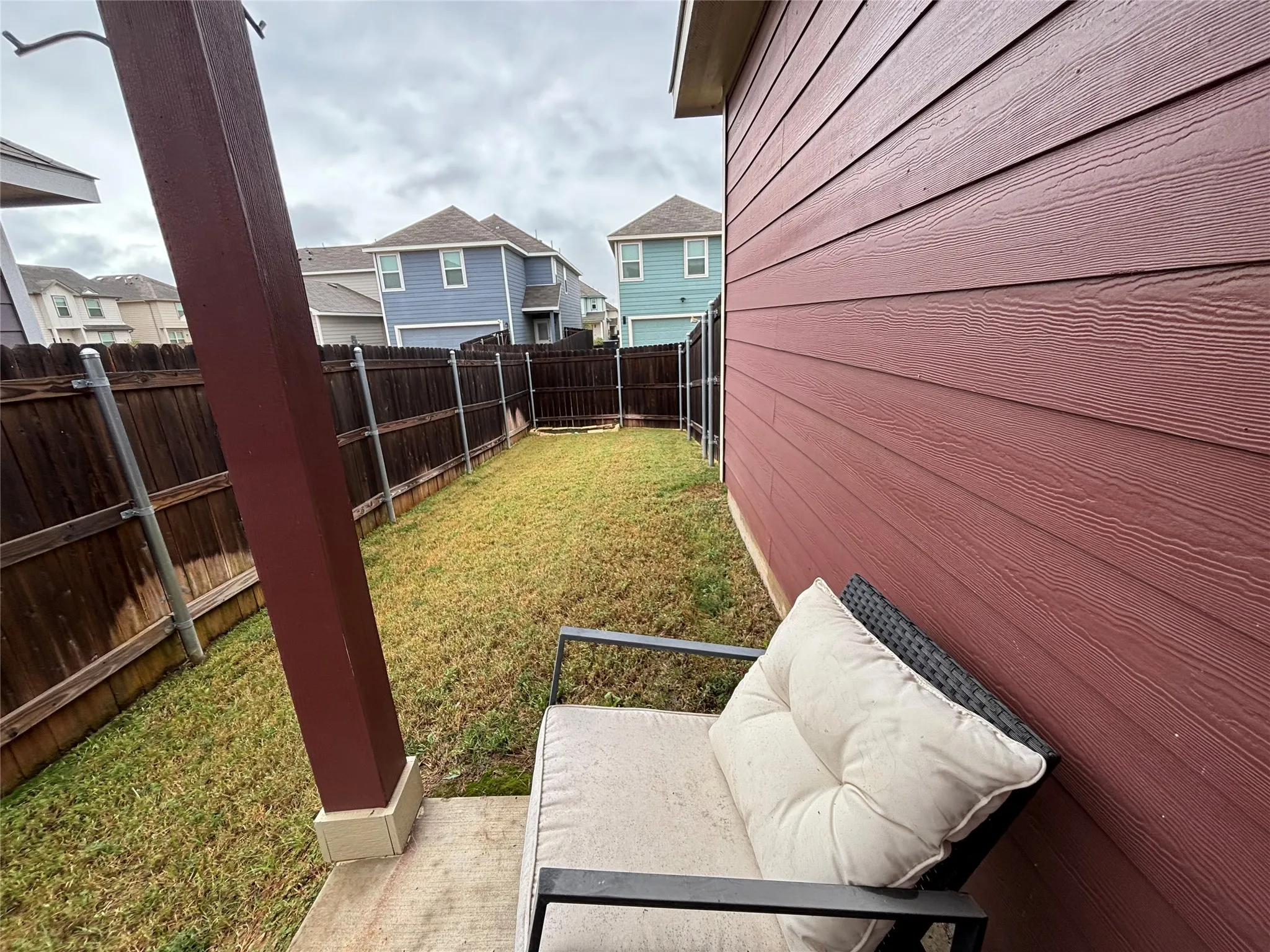 Expansive backyard featuring a manicured lawn, full wood fencing, and a concrete patio