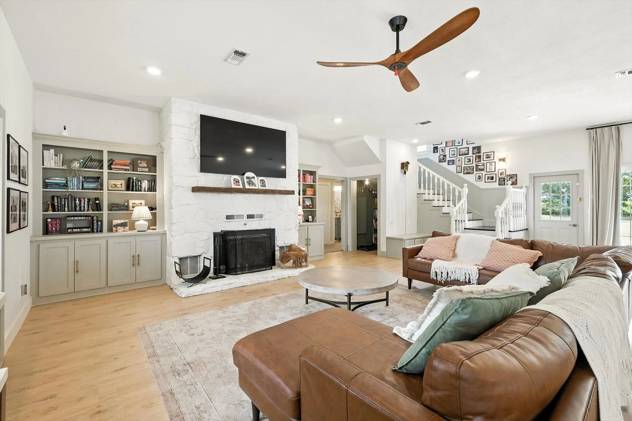 White stone fireplace with a wood mantel