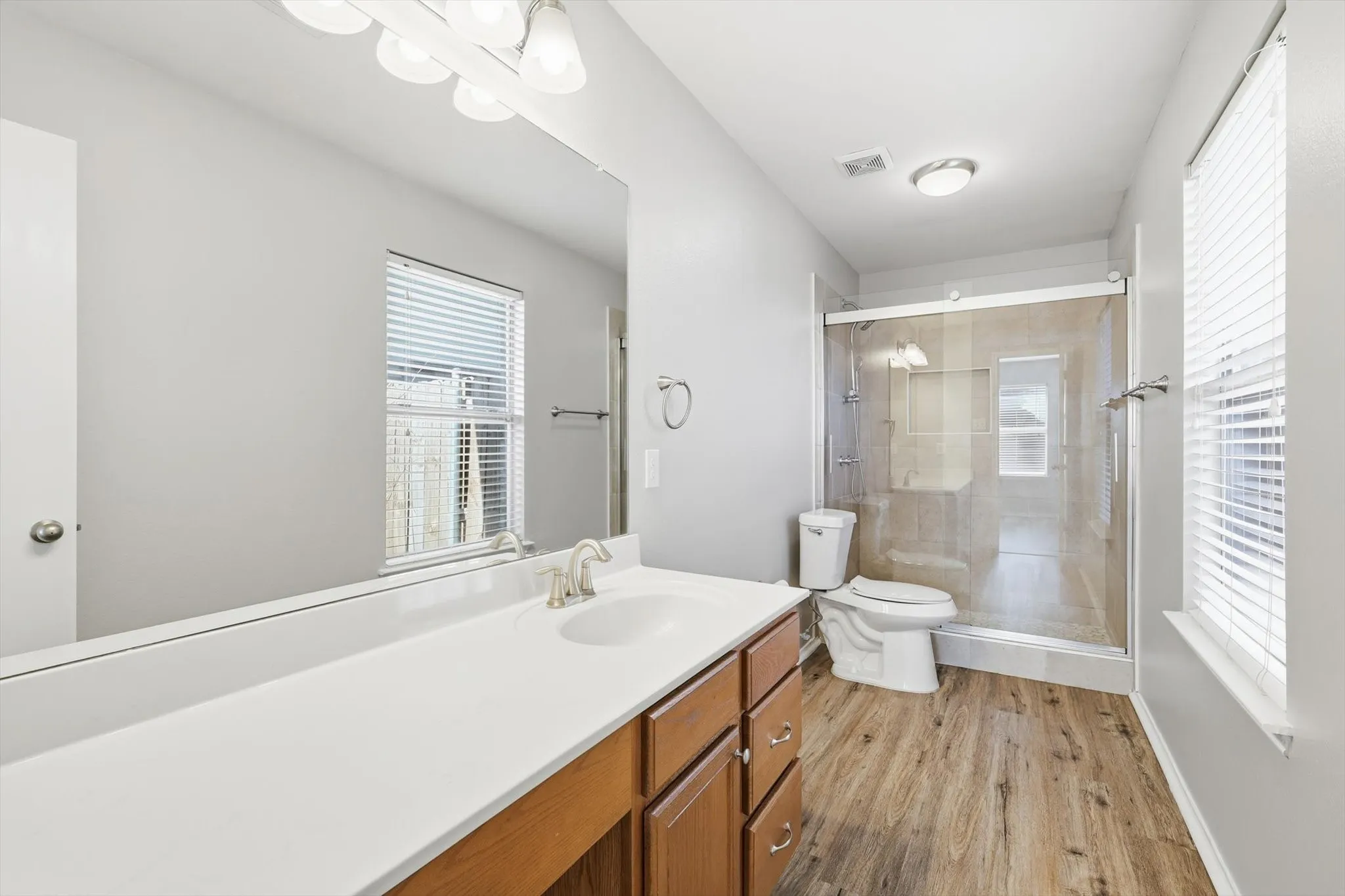 Double vanity with a white countertop and wood-finish cabinetry
