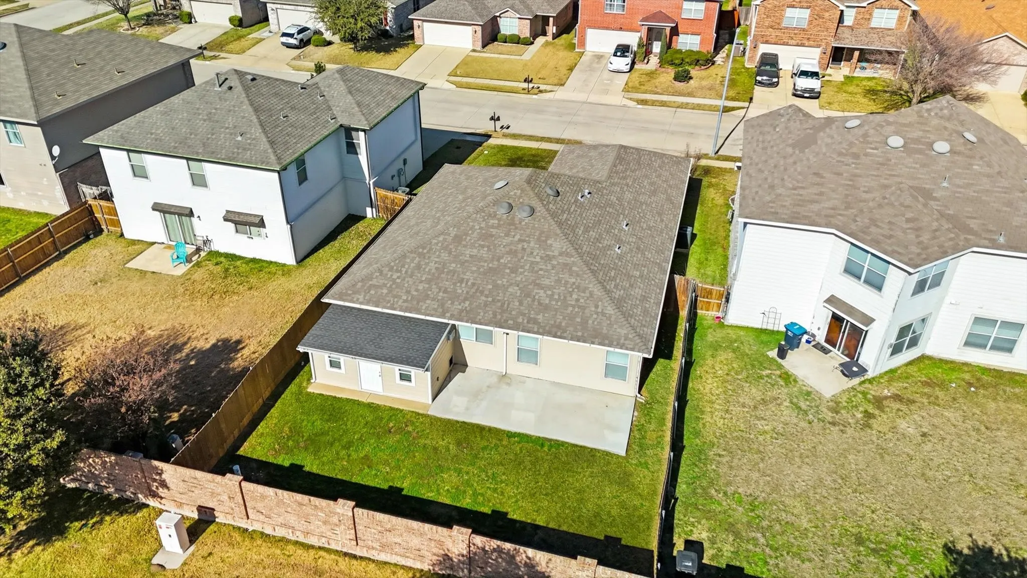 Fenced backyard featuring a concrete patio and a manicured lawn