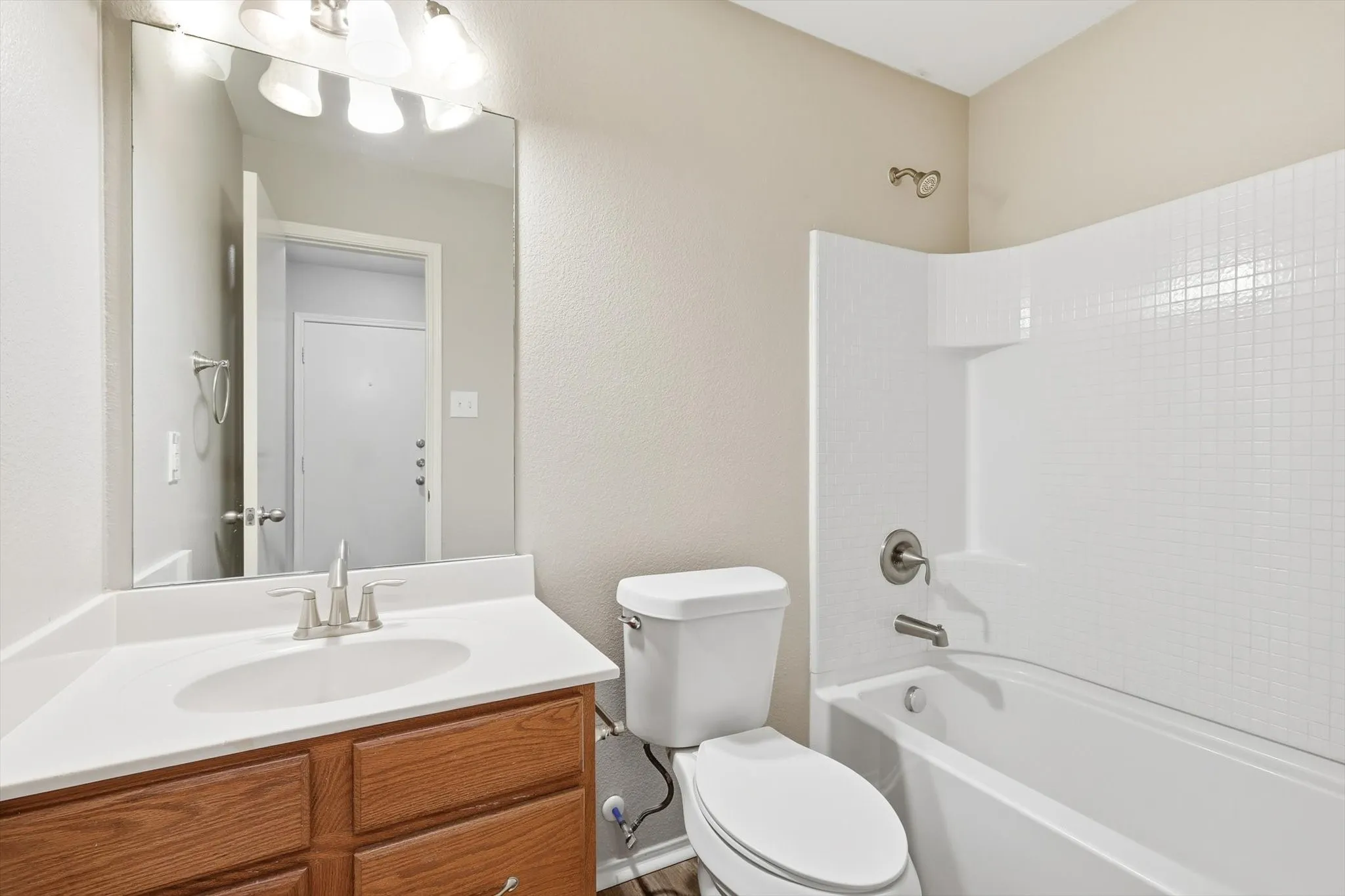 Wood-finish vanity with an integrated sink and white countertop
