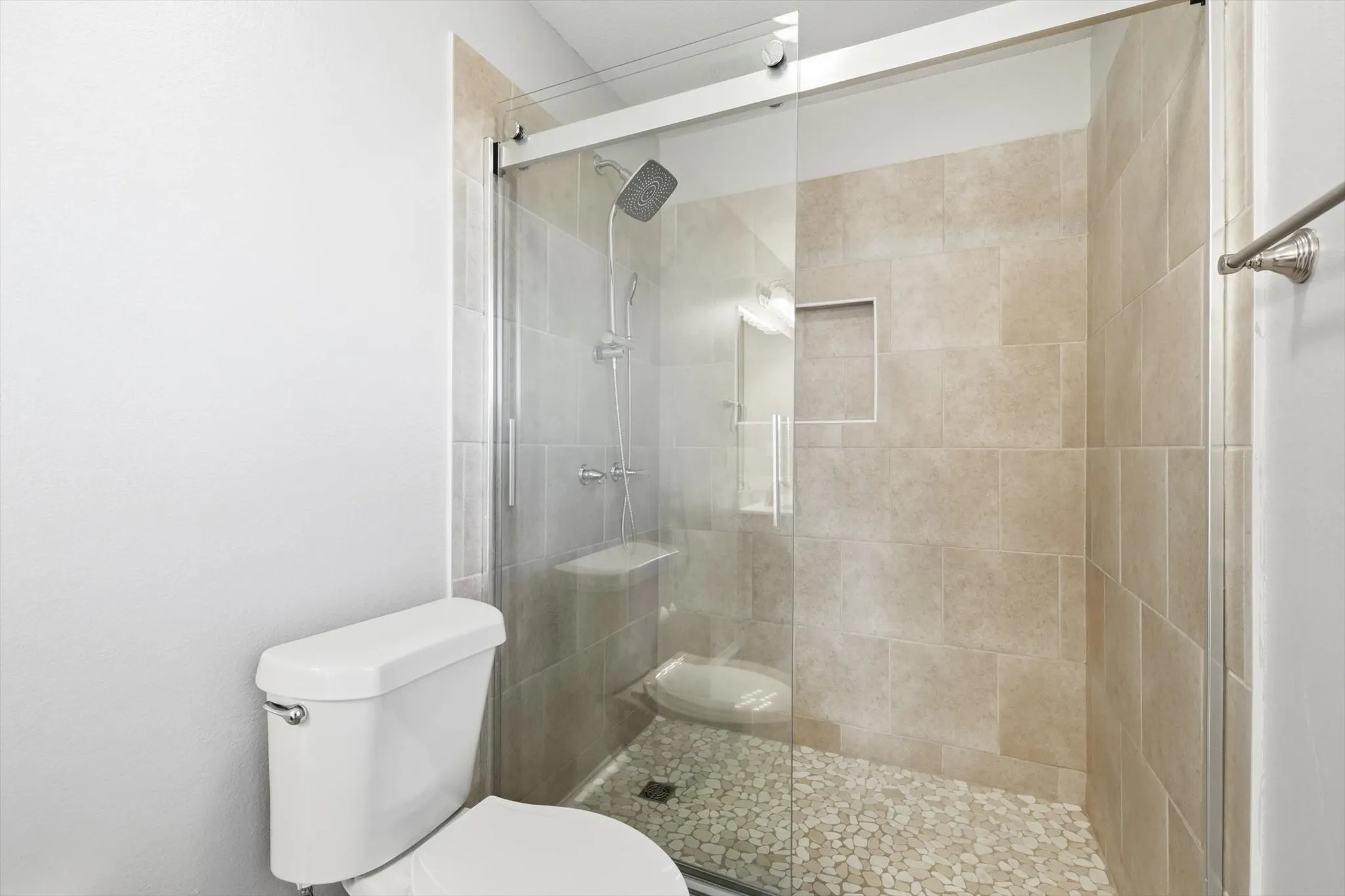 Walk-in shower with clear glass enclosure and sliding door