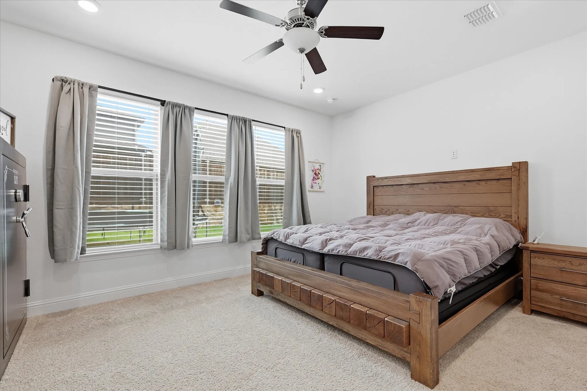 Recessed ceiling lighting, ceiling fan fixture, triple window arrangement, wall-to-wall carpeting, and white wall finishes