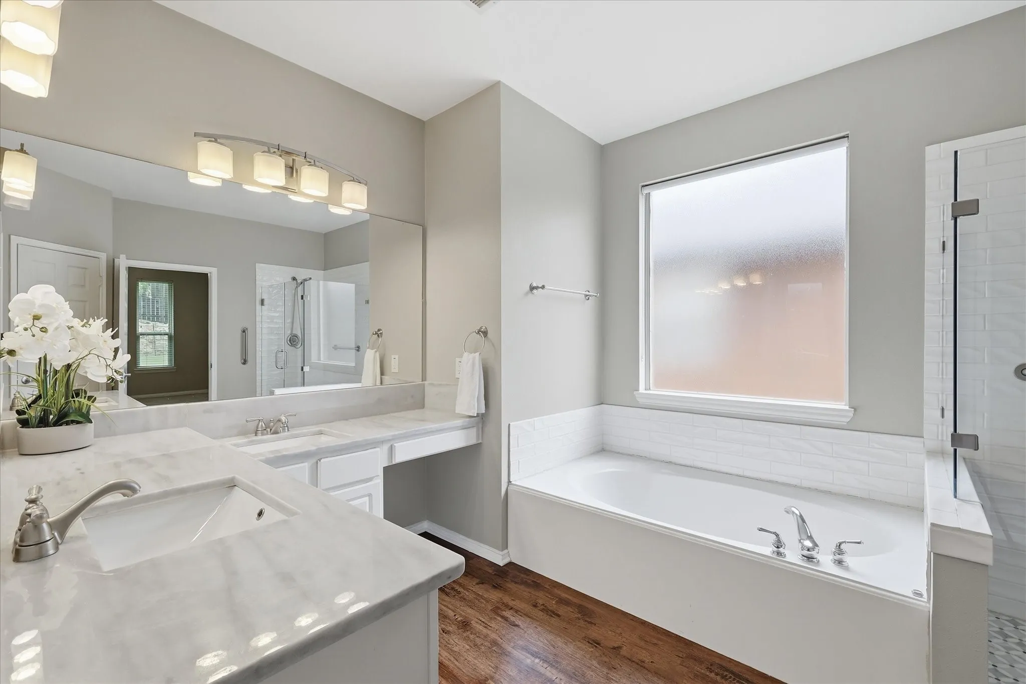 Double vanity with polished countertops, undermount sinks, and chrome faucets