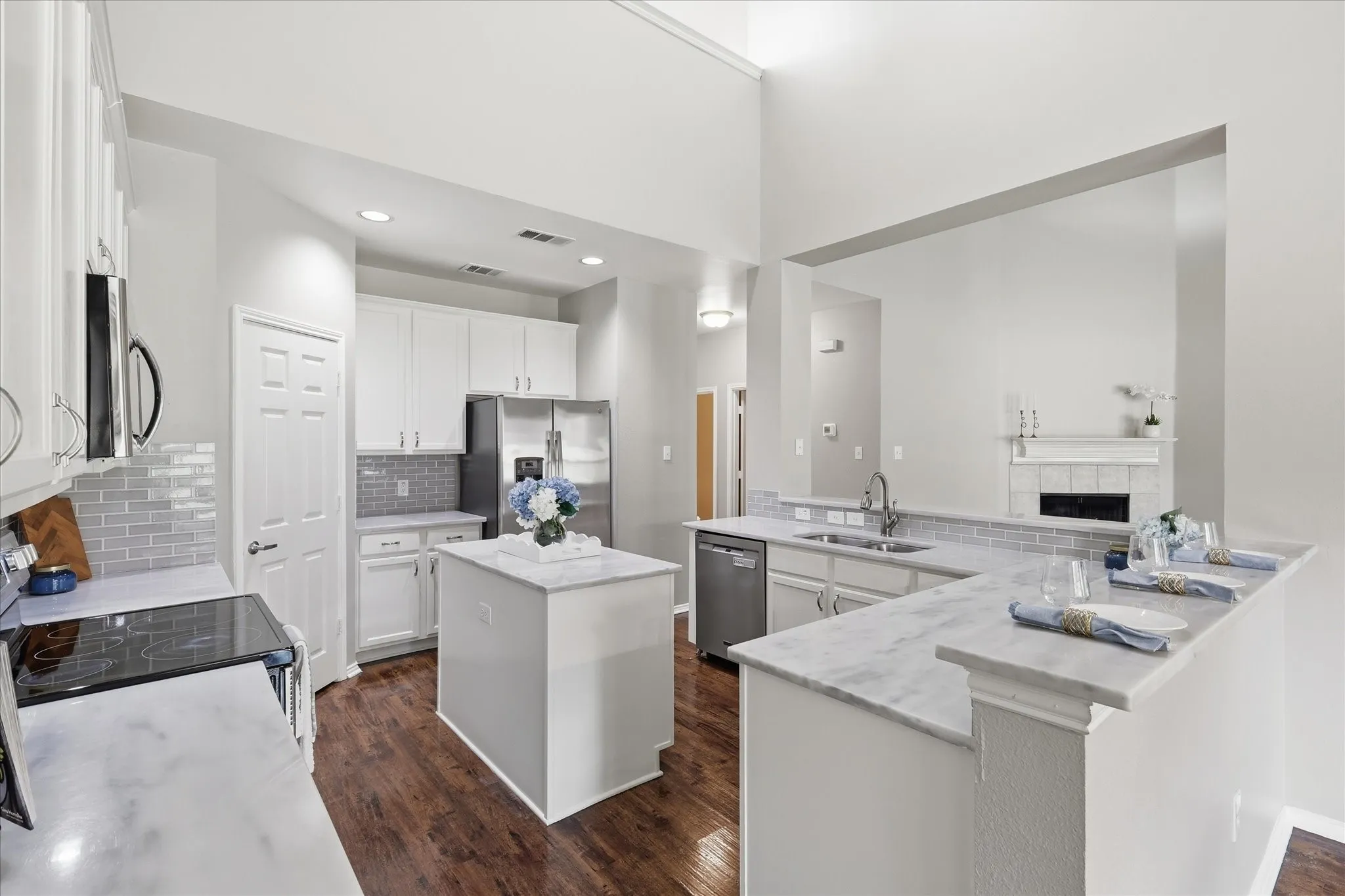 Kitchen featuring wood-finish flooring, white cabinetry, a center island with countertop, and stainless steel appliances