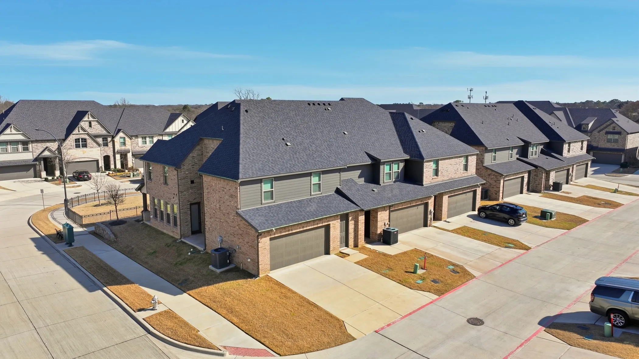 Brick and siding exteriors with dark shingle roofing, attached garages, and concrete driveways