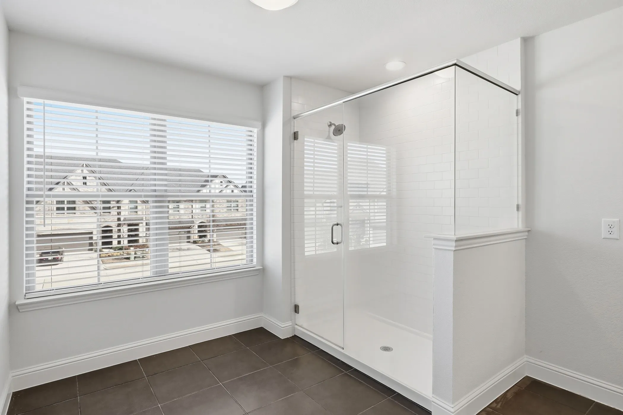 Walk-in shower with clear glass enclosure, subway tile surround, and an integrated shower base