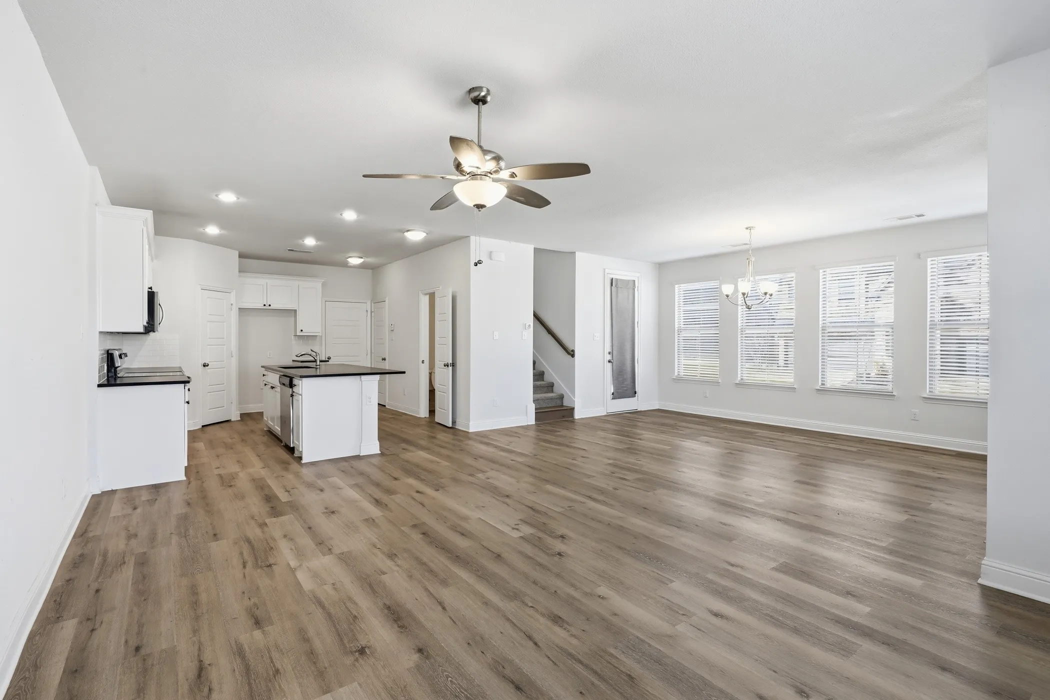 Kitchen with white cabinetry, dark countertops, and central island