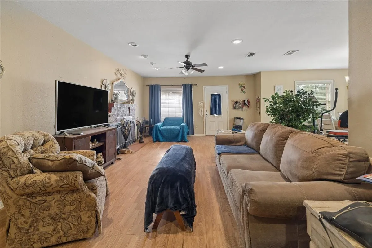 Alternate view of the open living space highlighting comfortable layouts and ceiling fan setup.