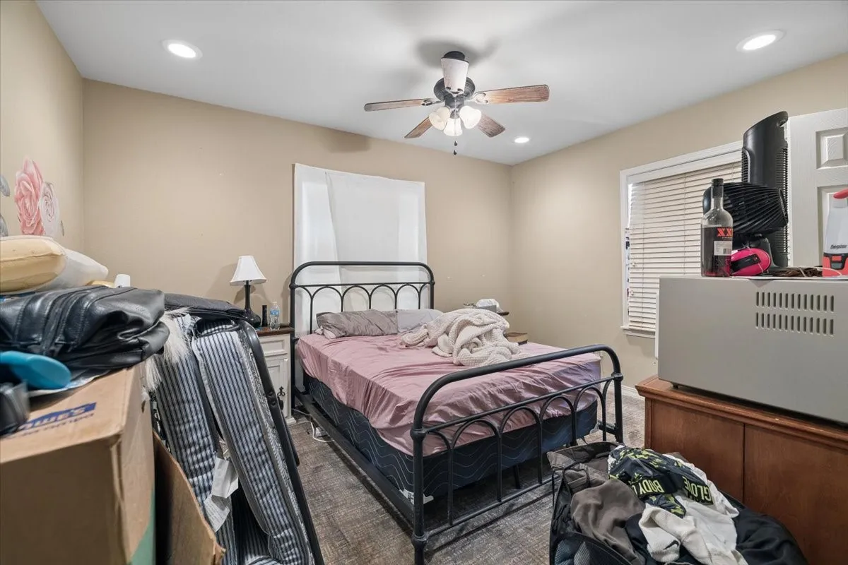 Well-proportioned bedroom with ample natural light and plush carpeting.
