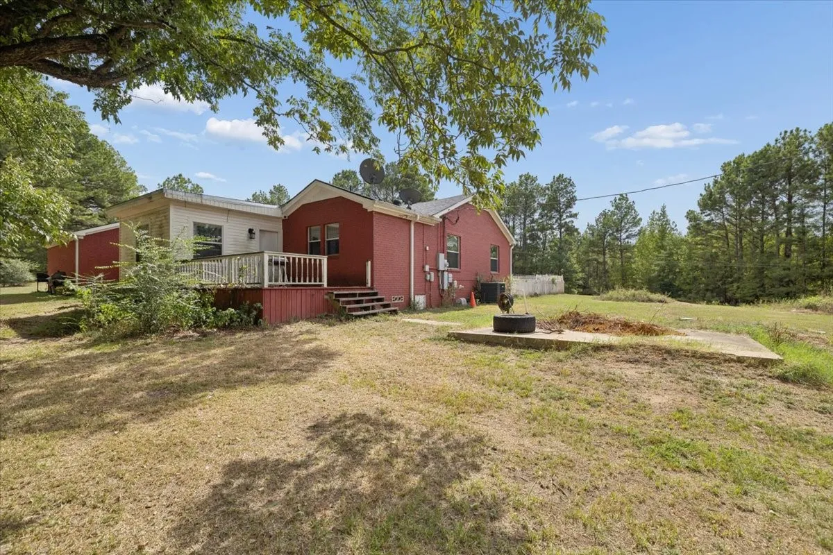 Rear elevation showing the spacious yard and surrounding natural landscape.