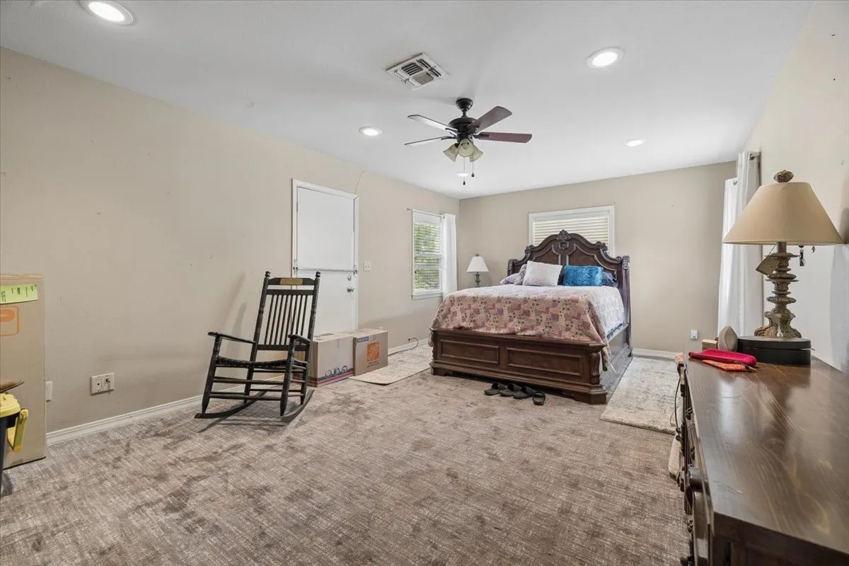 Generously sized bedroom featuring plush carpet flooring and clean, simple wall finishes.