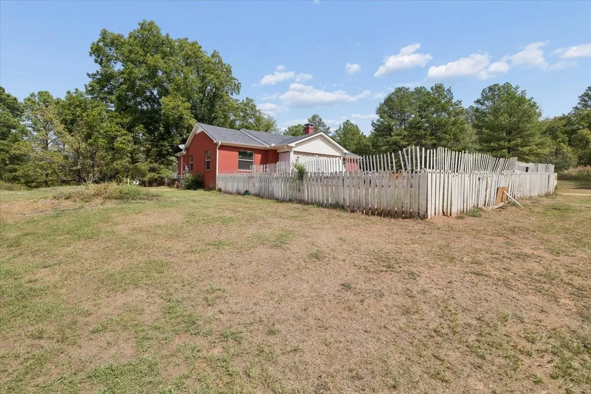 Wide view of the sprawling lawn and perimeter fencing.