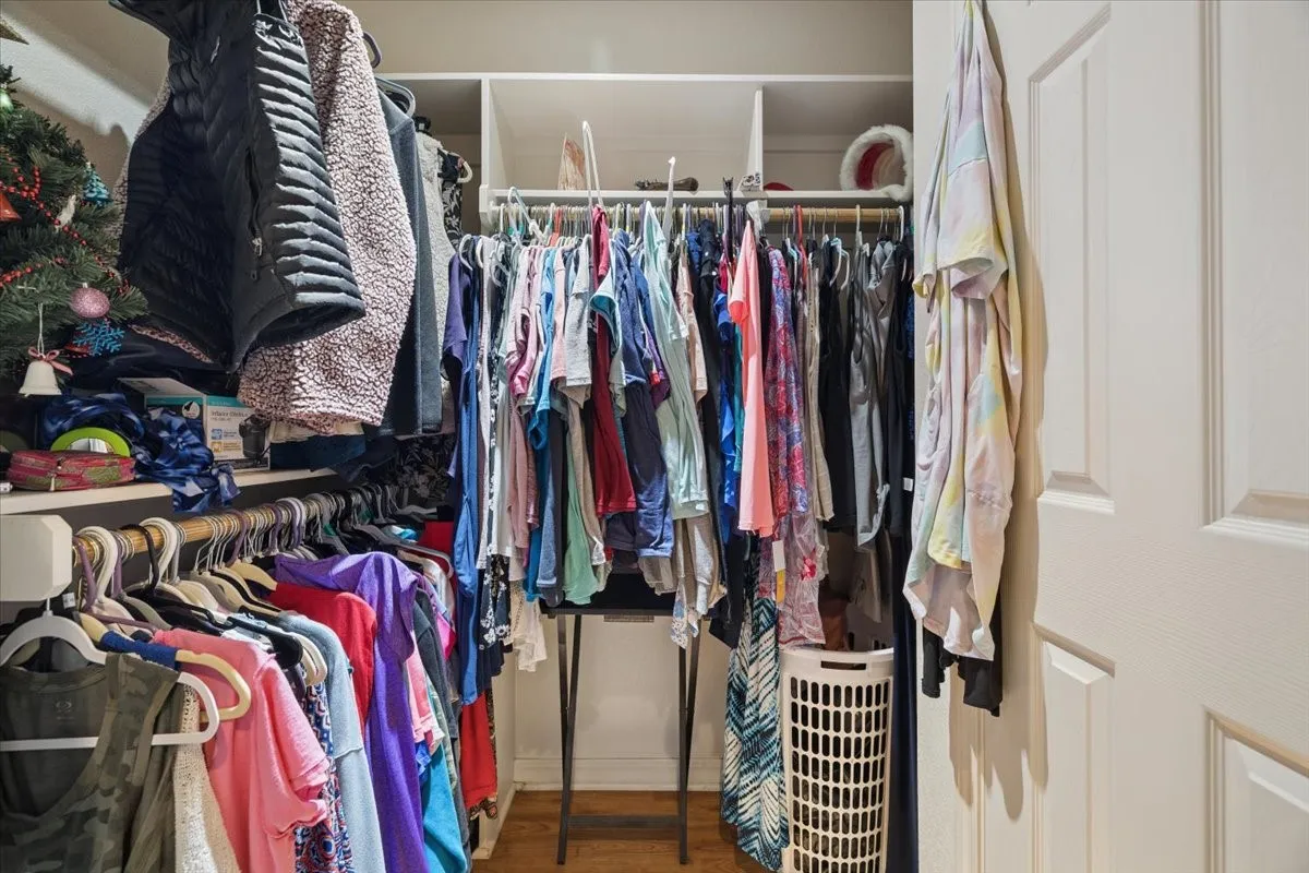Spacious walk-in closet complete with built-in organizational shelving and double hanging rods.