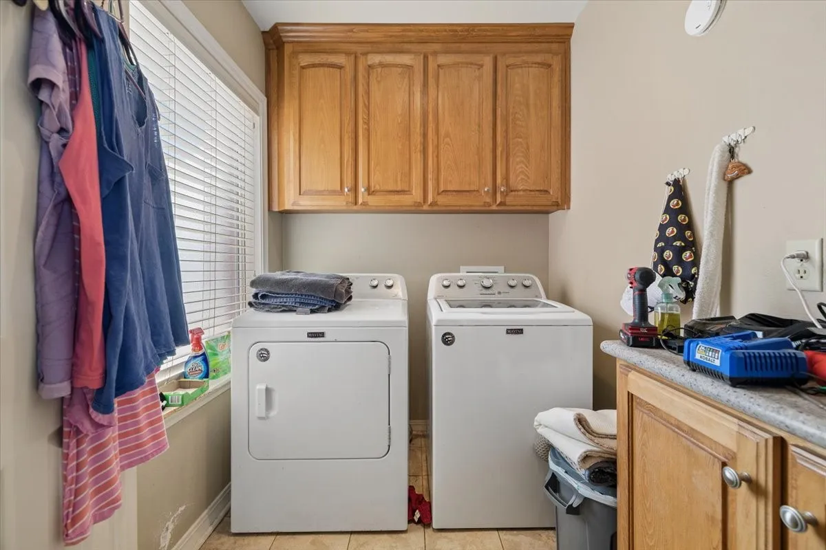 Dedicated laundry room featuring overhead cabinet storage and full washer/dryer hookups.
