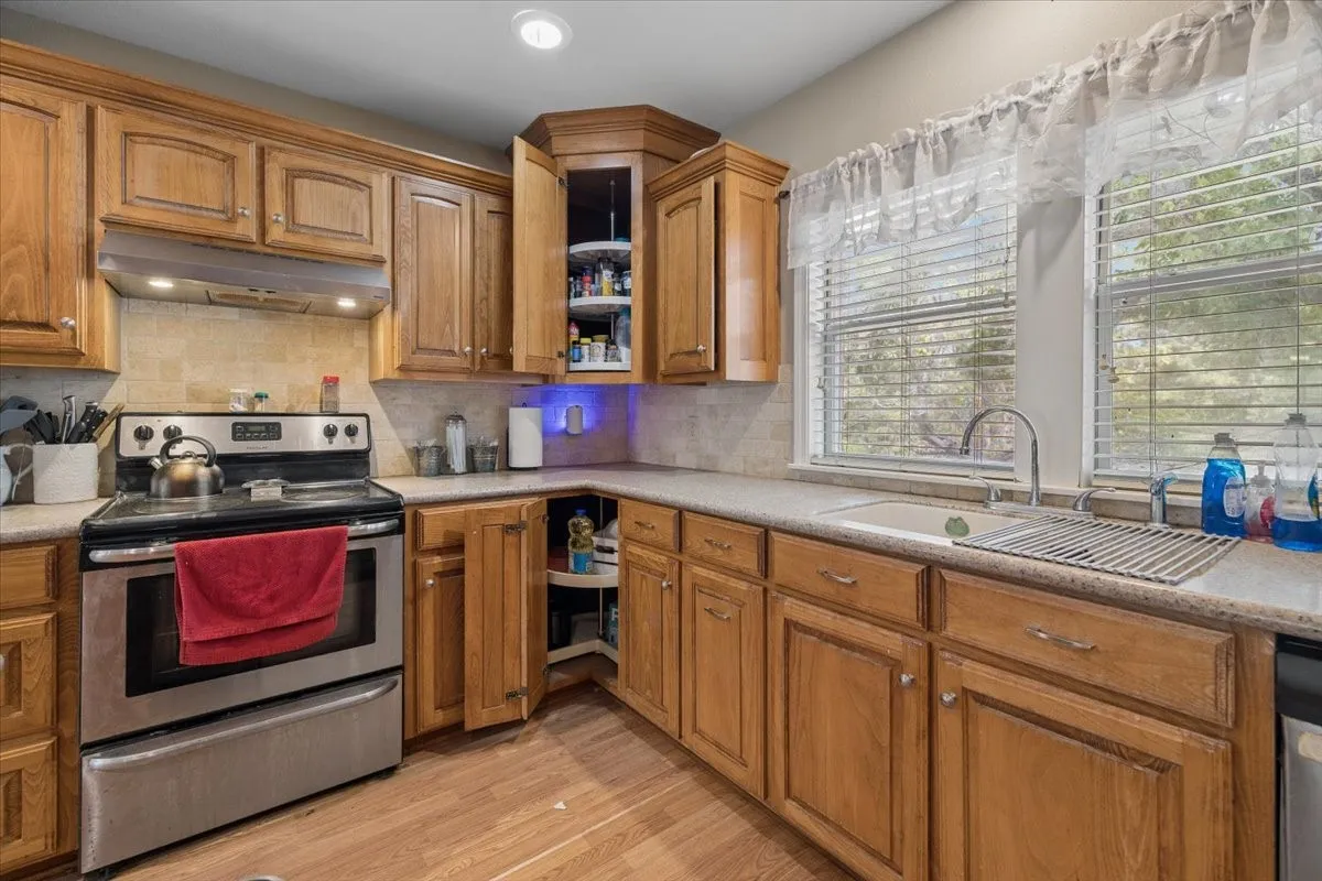 Spacious kitchen featuring warm wood cabinetry, modern stainless steel appliances, and ample counter space.