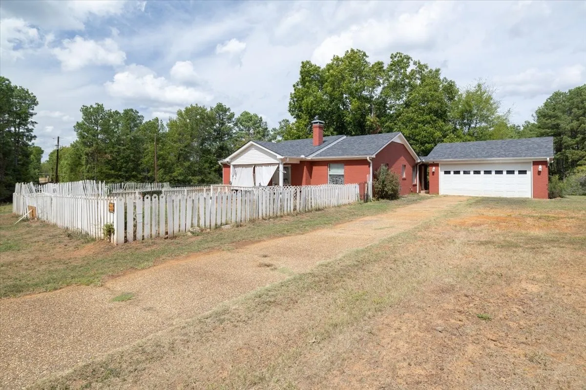 Front property view showing approach, wide open yard, and surrounding scenery.