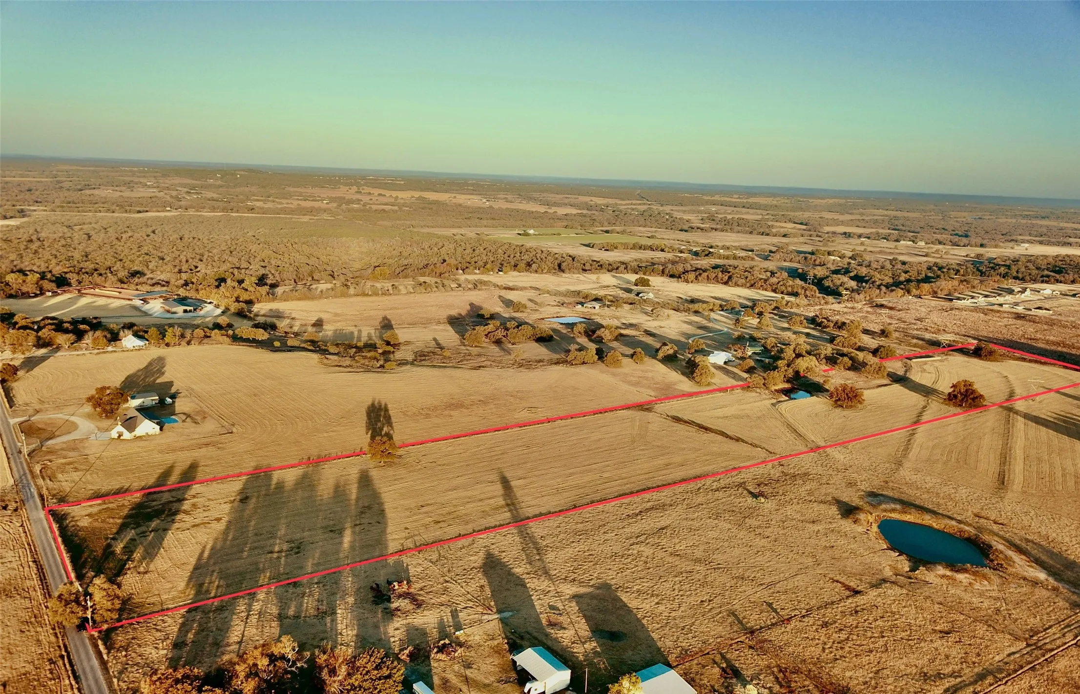 Expansive rural property featuring an established pond and surrounding open acreage