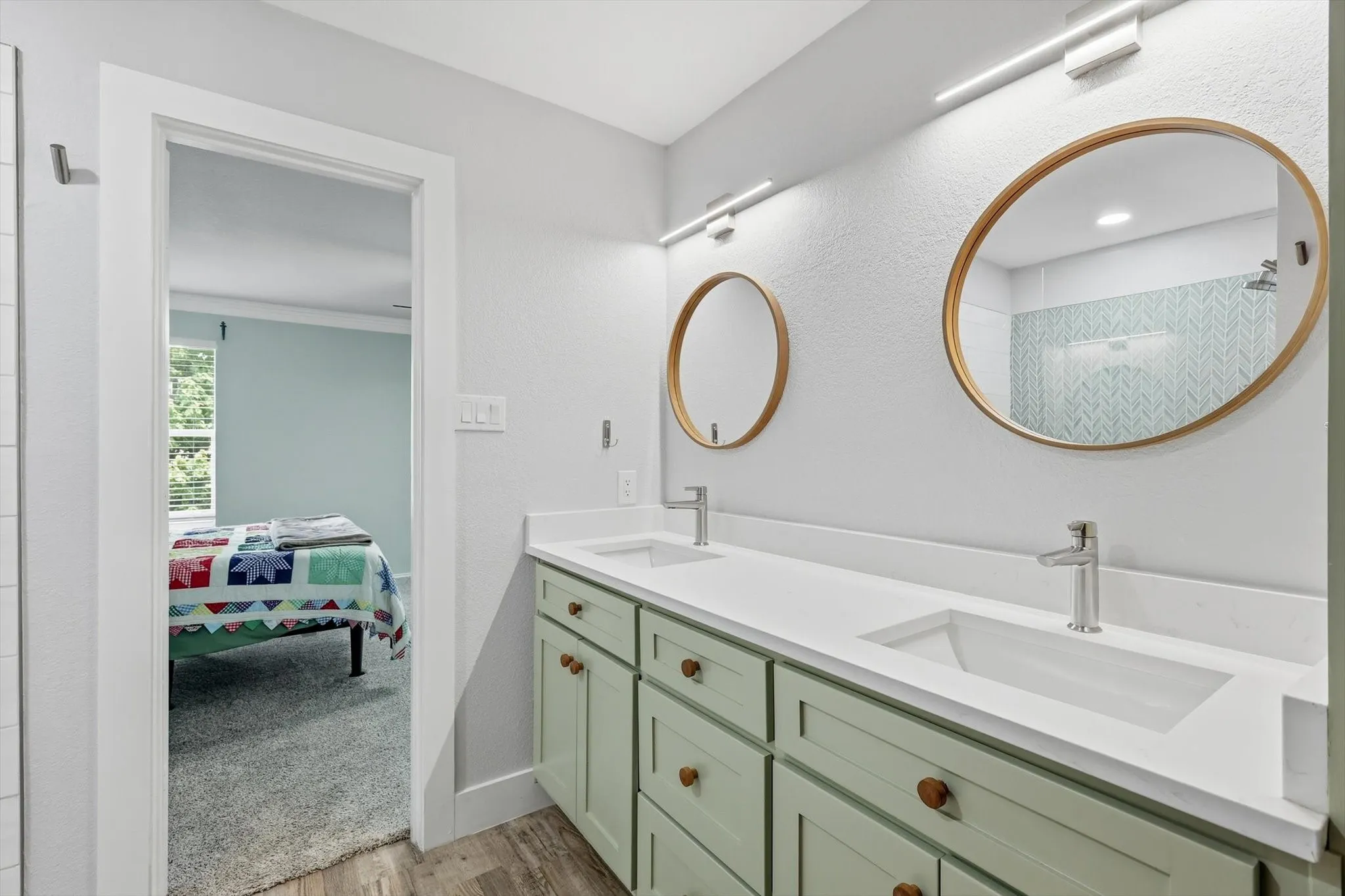 Dual vanity with light green cabinetry, white countertops, and integrated rectangular sinks
