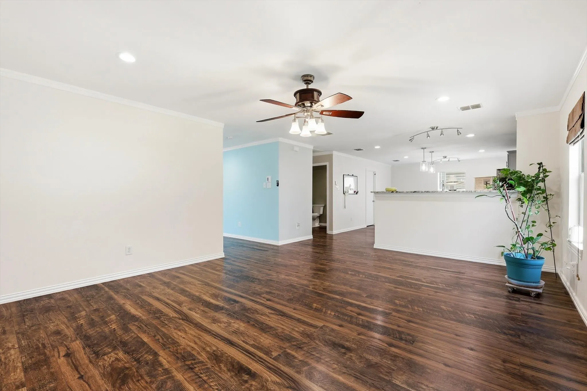 Spacious open-concept interior featuring wood-finish flooring, recessed lighting, and a ceiling fan
